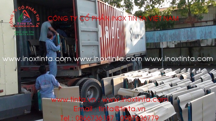 Hình ảnh công nhân đang bốc dỡ bàn ghế inox từ container tại khu vực kho bãi nhà máy TIN TA, chuẩn bị cho quá trình vận chuyển đi lắp đặt.